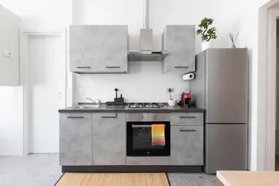 a kitchen with a stove and a refrigerator at Maison Margaret in Rome