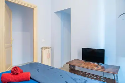 a living room with a bed and a tv at Lion Renting Metro Piramide in Rome