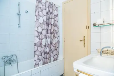 a bathroom with a shower curtain with a tub and a sink at Lion Renting Metro Piramide in Rome