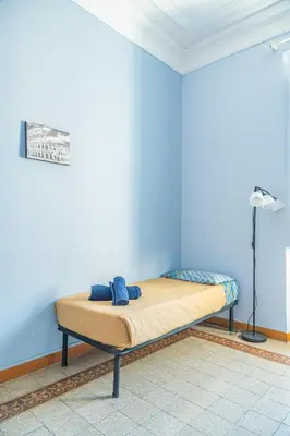 a bed in a room with a blue wall at Lion Renting Metro Piramide in Rome
