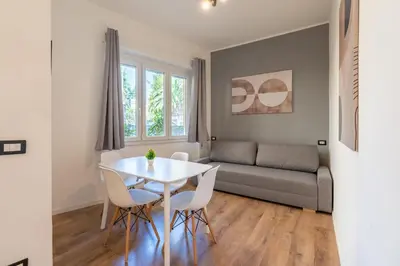 a living room with a table and chairs and a couch at Central Modern Apartment - Colosseo 10 min in Rome