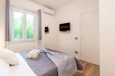 a bedroom with a bed and a tv on the wall at Central Modern Apartment - Colosseo 10 min in Rome