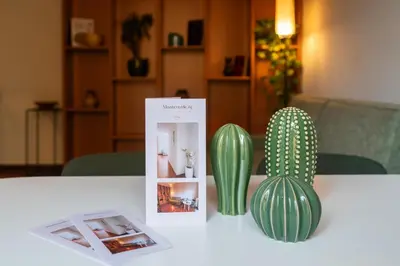 a table with two green cactuses and a magazine at Monteverde 65 in Rome