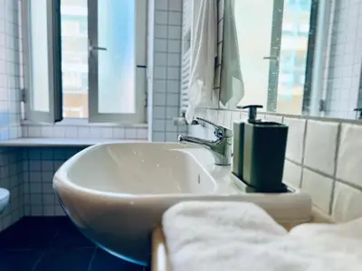 a white sink in a bathroom with a window at Monteverde 65 in Rome