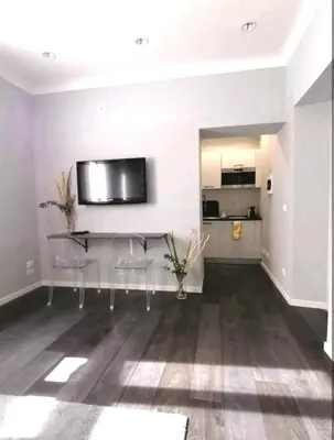 a living room with a table and chairs and a kitchen at Piazza di Spagna Suite in Rome