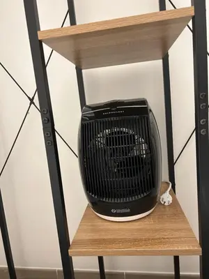 a small black heater sitting on a wooden shelf at Lovely apartment in the center of Rome, Monti in Rome