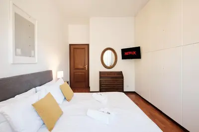 a large white bed in a room with a mirror at Elegante appartamento con 3 Camere da letto vicino il Centro in Rome