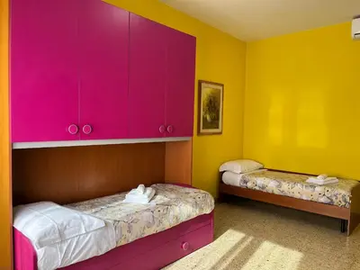 a room with two beds and a pink cabinet at Sweet Holiday Gardenie in Rome