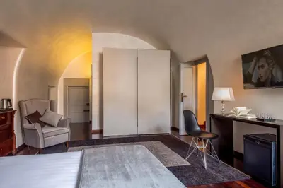 a living room with a cabinet and a chair at Palazzo De Cupis - Suites and View in Rome