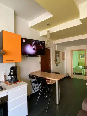 a kitchen with a desk and a tv on the wall at Alloggio di Raffaello L in Rome