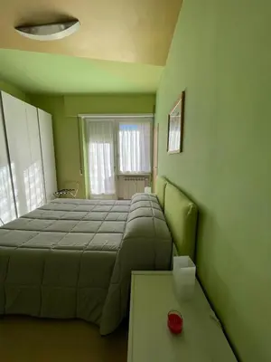 a green bedroom with a bed and a table at Alloggio di Raffaello L in Rome