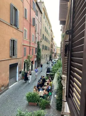 a group of people sitting at a table on a street at Bottega Augustea Duplex apartment in Monti in Rome