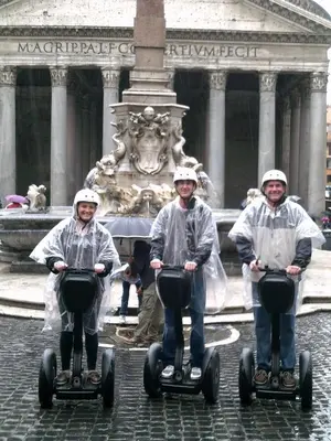 three people riding on segways in front of a fountain at Space Home in Rome