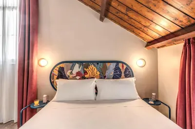 a bedroom with a large bed with a wooden ceiling at Hotel XX Settembre in Rome