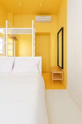 two beds in a room with yellow walls at Reale Vatican House in Rome