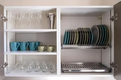 a white cabinet with plates and glasses on it at Testaccio Design Apartment Rome in Rome