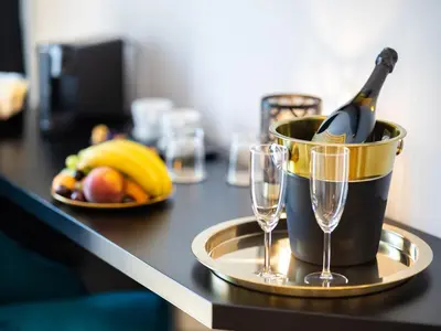 a bottle of champagne in a bucket on a table with two glasses at Regola Luxury Relais in Rome