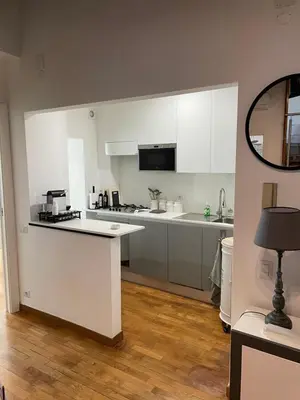 a kitchen with white cabinets and a counter top at Loft 643 in Rome