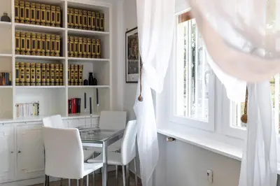 a dining room with a table and white chairs at Caracalla garden House in Rome