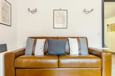 a brown leather couch with three pillows on it at Caracalla garden House in Rome