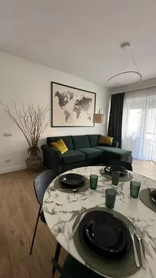 a living room with a green couch and a table at A casa di Ren in Rome