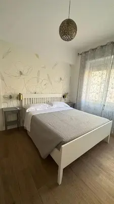 a bedroom with a large bed with a white bedspread at A casa di Ren in Rome