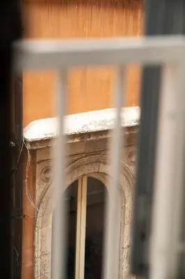 a window with a reflection of a building at Rome Center Apartment Campo De' Fiori in Rome