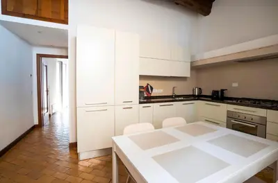 a kitchen with white cabinets and a white table at Rome Center Apartment Campo De' Fiori in Rome