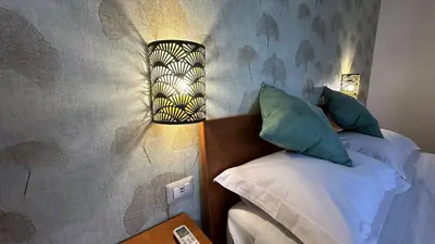 a bedroom with a bed and a lamp on the wall at A casa di Edo in Rome