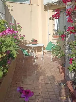 a patio with a table and chairs and flowers at Le Buganville in Rome