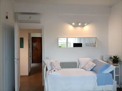 a white bedroom with a bed and a window at Le Buganville in Rome