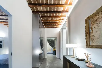 a living room with a wooden ceiling and a hallway at Trastevere Luxury, ampia e confortevole location sospesa tra design e storia in Rome