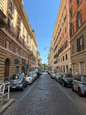 a cobblestone street with parked cars in a city at Luxury Apartment Via Veneto in Rome