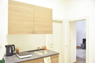 a kitchen with a sink and wooden cabinets at Giulia Mesa Suites in Rome