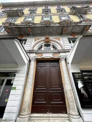 a brown door on a building with two windows at Giulia Mesa Suites in Rome
