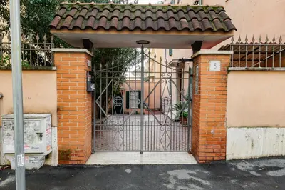 an open gate to a brick building with a gate at Appartamento a Roma a due passi da Trastevere in Rome