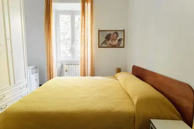 a bedroom with a yellow bed and a window at Appartamento a Roma a due passi da Trastevere in Rome