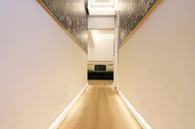 an empty hallway with white walls and wood floors at The Brick Apartment by Nosdom Properties in Rome