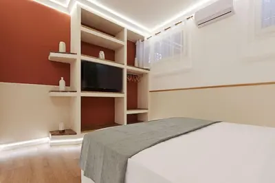 a bedroom with a bed and a flat screen tv at The Brick Apartment by Nosdom Properties in Rome