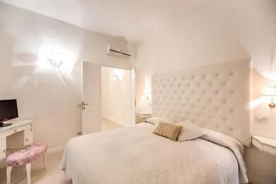 a white bedroom with a bed and a television at Elegant Flat Spanish steps in Rome