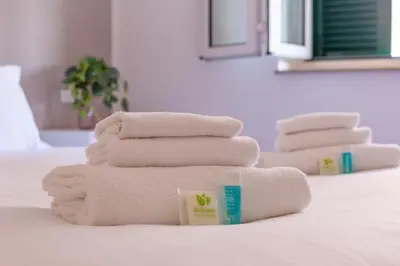 a stack of towels sitting on a bed at iFlat Bright Brand New 2-Bedroom Apt in Monti in Rome