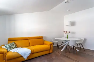 a living room with a yellow couch and a table at iFlat Bright Brand New 2-Bedroom Apt in Monti in Rome