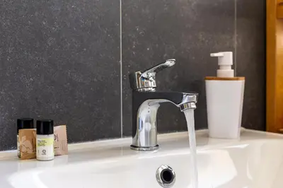 a bathroom sink with a faucet and a cup on it at iFlat Retro Style Apartment near the Vatican in Rome