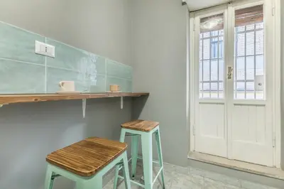 a kitchen with two stools and a counter and a window at House Grimaldi in Rome