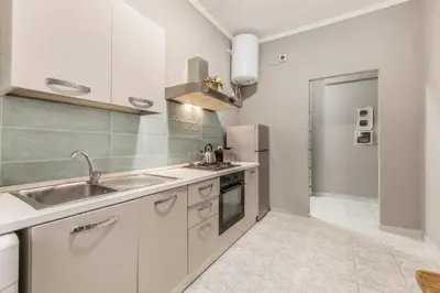 a kitchen with white cabinets and a sink at House Grimaldi in Rome