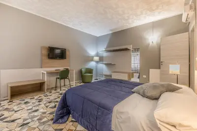a bedroom with a bed and a desk and a television at House Grimaldi in Rome