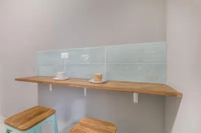 a wooden shelf with two cups and two stools at House Grimaldi in Rome