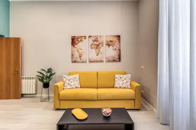 a living room with a yellow couch and a table at Pretorius Charming New Apt in Rome