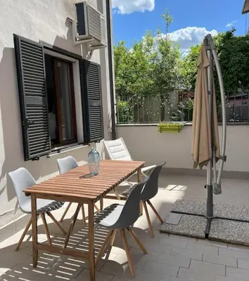 a wooden table and chairs and an umbrella on a patio at Urban Retreat in Rome