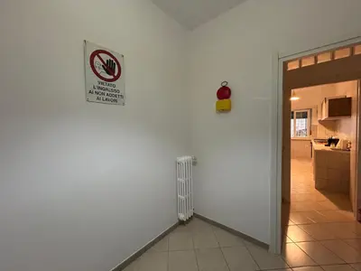 a room with a white wall with a sign on the wall at Peppe's Bed in Rome